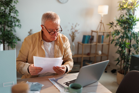 Man using his laptop and looking at documents